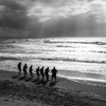 Silhouette of athletes running on Borkum beach. Black and white, dynamic and captivating.